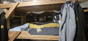 Hier sieht man den Nachbau einer Massenunterkunft im Ghetto Terezín. 60 Menschen mussten hier in Mehrstockbetten schlafen. Bettwanzen, Kälte, Hitze, Krankheiten, Hunger, fehlende medizinische Versorgung und die Willkürherrschaft der Nazis machten den meist jüdischen Menschen das Leben zur Hölle.